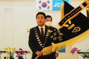 제52대 광천청년회의소 회장으로 취임한 이정윤 회장이 깃발을 흔들어 보이고 있다.