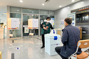 9일 정오경 홍북읍 제4투표소에서 투표용지를 투표함에 넣고 있는 한 유권자의 모습.