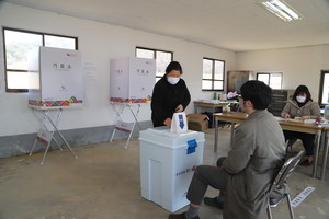은하면 제2투표소인 중가마을 구회관 1층에서 투표를 마친 유권자가 투표함에 투표용지를 넣고 있는 모습.