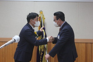 총동창회기를 전달받고 있는 이충수 신임회장.