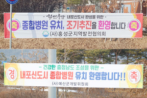 내포신도시종합병원 유치 환영 홍성군지역발전협의회 현수막(사진 위). 내포신도시종합병원 유치 환영 예산군개발위원회 현수막(사진 아래).