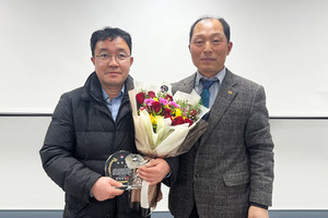 신입회원 위촉패를 전달받은 김병주 씨와 이완희 회장의 기념사진.