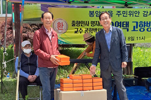 박갑순&nbsp;봉암마을 이장과 오영택 교수가 선물을 교환하고 있다.