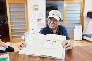 광천 석면광산에서 일했던 시절의 이야기를 엮은 책 ‘하얀꽃’을 들고 있는 박재덕 씨.