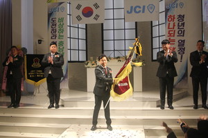 2024년 홍성청년회의소를 이끌어 갈 김민재 취임회장이 홍성JC기를 흔들어 보이고 있다.