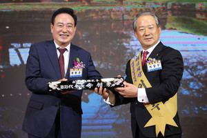 복봉규 이임회장이 이상수 취임회장에게 명패를 전달하고 있다.