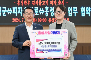 이날 이재욱 피자알볼로 대표(오른쪽)는 업무협약을 마치고 이용록 홍성군수에게 홍성사랑기부금 500만 원을 기탁했다.