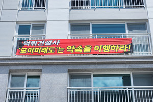 입주민들이 아파트 외부에 내건 현수막. 시공사에 약속된 하자 보수를 신속히 처리해 줄 것을 요구하고 있다.&nbsp;