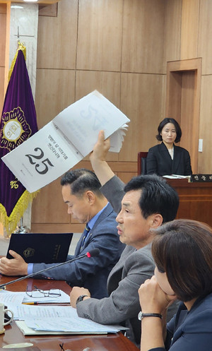 권영식 의원이 용역의 결과물인 일력을 직접 들어 보이며 거칠게 항의하고 있다.