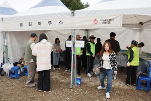 쓰레기를 분리 배출할 수 있는 셀프하우스에서 자원봉사자들이 분리 배출을 돕고 있는 모습.