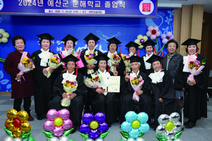 졸업식에서 학사모를 쓴 삽교읍 상성2리 교실 어르신들이 졸업장과 축하 꽃다발을 들고 환하게 웃고 있다.