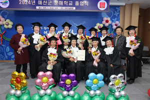 졸업식에서 학사모를 쓴 삽교읍 상성2리 교실 어르신들이 졸업장과 축하 꽃다발을 들고 환하게 웃고 있다.
