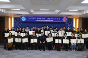2025년 모범음식점으로 지정된 업주들이 지정증을 들고 최재구 군수와 단체사진.