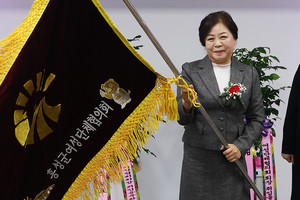임호자 신임 홍성군여성단체협의회장이 전정숙 이임회장이 전달해 준 협의회기를 흔들어 보이고 있다.