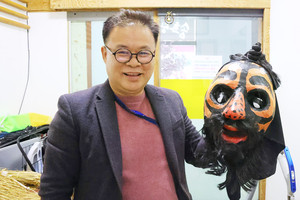 김동남 단장이 발탈을 손에 들고 웃고 있다.