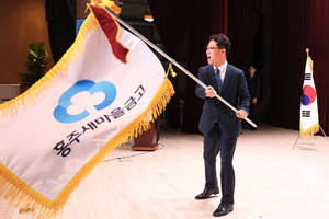 김택노 이사장이 건네받은 금고기를 힘차게 흔들고 있다.