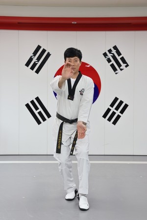 송 관장이 태산밀기 동작을 취하고 있다.