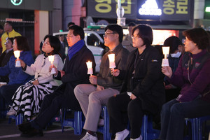 유가족을 비롯한 지역민, 내빈들이 촛불을 들고 공연을 관람하고 있다.