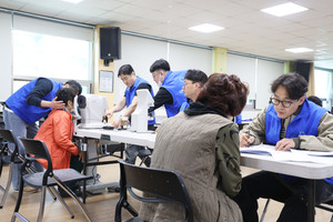 어르신들이 시력검사를 받고 있다.