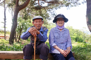 맨발로 황톳길을 걷던 임광배(남장리, 92)·모부심(남장리, 85) 어르신이 나무 벤치에 앉아 휴식을 취하고 있다.
