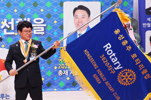 한정훈 홍성홍주로타리클럽 신임회장이 클럽기를 흔들어 보이고 있다.