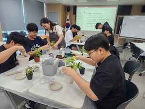 학생들이 자연 친화적 과제 실습인&nbsp;반려 화분 만들기를 하며 즐겁게 웃는 모습.