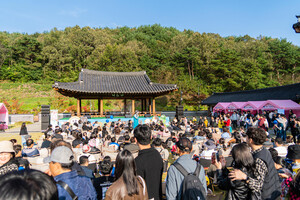 사명대사공원 전통무대에서 열린 공연 프로그램 현장. 가족 단위 관람객들이 잔디밭에 앉아 버스킹과 공연을 즐기고 있다.