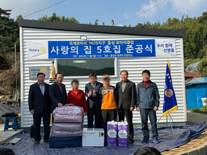 준공식에 참가한 홍성로타리클럽 관계자와 새 보금자리를 얻게된 가구가 기념 촬영을 하고 있다.