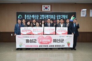 홍성군·예산군 민·관 상호기부를 마치고 이용록 군수를 비롯한 관계자들이 기념촬영을 하고 있다.