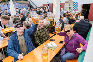 건배를 외치며 거대한 맥주잔을 부딪쳐 올리고 축제의 순간을 함께 나누고 있다.