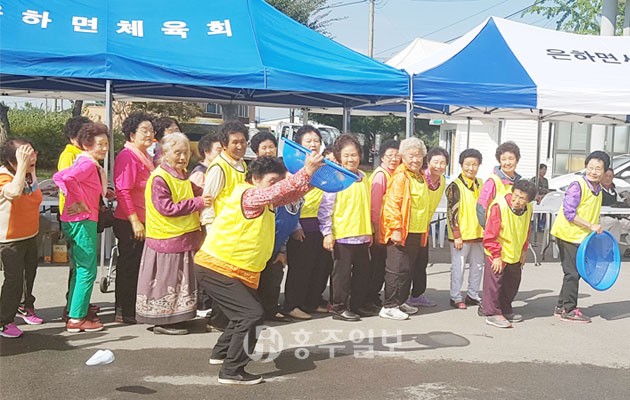 제2회 은하봉 들돌축제 참가자가 바구니에 고무신을 받고 있다.