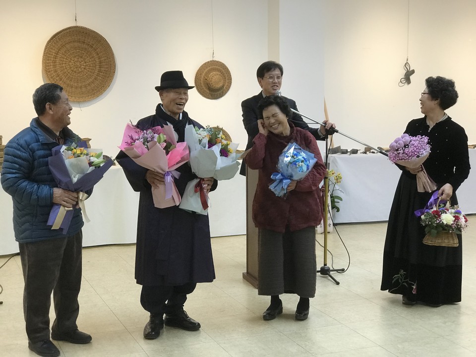 홍성의 무형문화재 기능보유자들이 제1회 ‘대를 잇는 홍성의 무형문화재 작품전시회’를 통해 모였다. 지난 2일 개막식에 참석한 기능보유자들이 꽃다발을 들고 기뻐하고 있다.