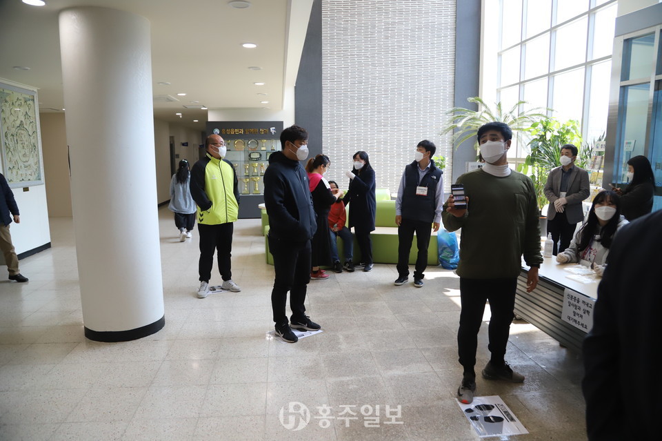 사전투표소 입구 바닥에 부착해 놓은 '사회적거리두기' 안내 문구 위에서 유권자들이 본인의 투표순서를 질저정연하게 기다리고 있다.