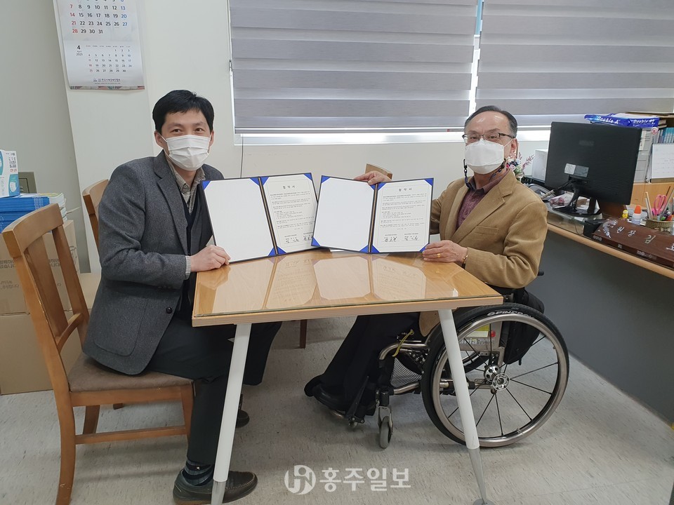 홍성군장애인보호작업장  김호현 원장(사진 오른쪽)과 홍성군장애인가족지원센터 엄기문 대표가 업무협약을 체결했다.