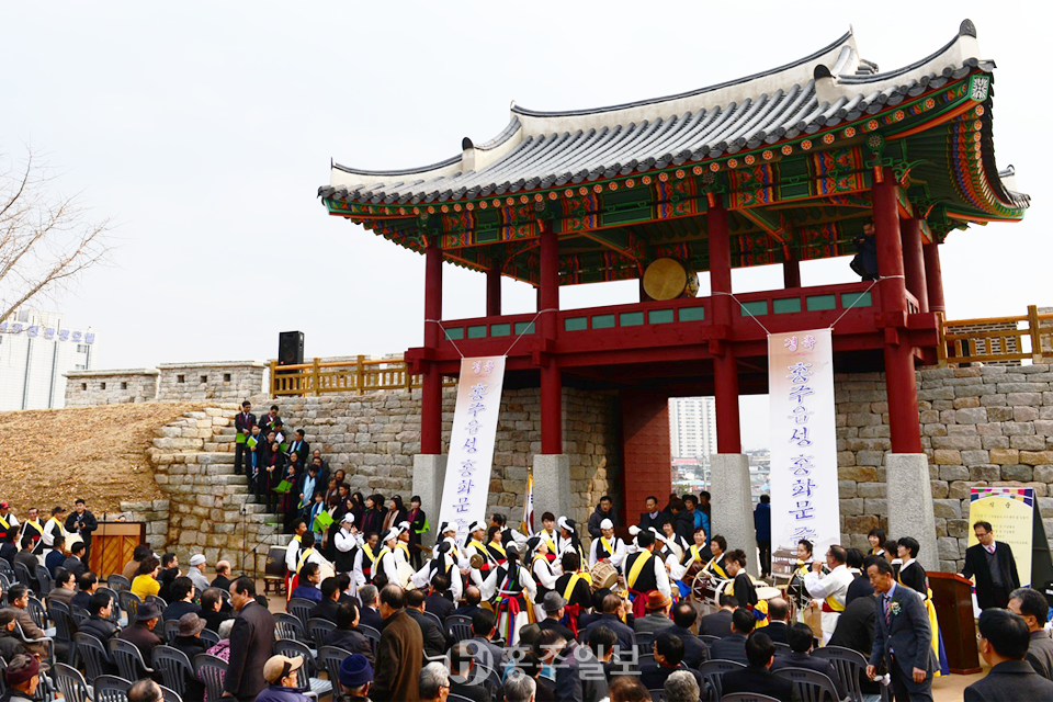 문헌으로만 전해지던 홍주성 남문이 복원돼 홍화문이란 이름으로 대중 앞에 당당한 위용을 드러냈다. 군은 지난 2일 200여명의 군민들이 참석한 가운데 남문복원 준공식을 개최하고 제막식, 축하공연 등을 진행했다. 사진은 남문복원 준공식에서 풍물패의 길놀이와 합창단 공연이 펼쳐지고 있는 모습.사진=김혜동 기자