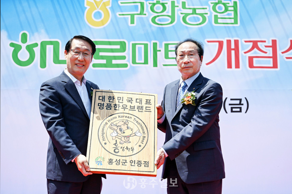 이용록 홍성군수(사진 왼쪽)에게 대한민국 대표 명품 한우브랜드 ‘홍성한우’ 인증 명패를 전달받고 있는 황규진 구항농협조합장.