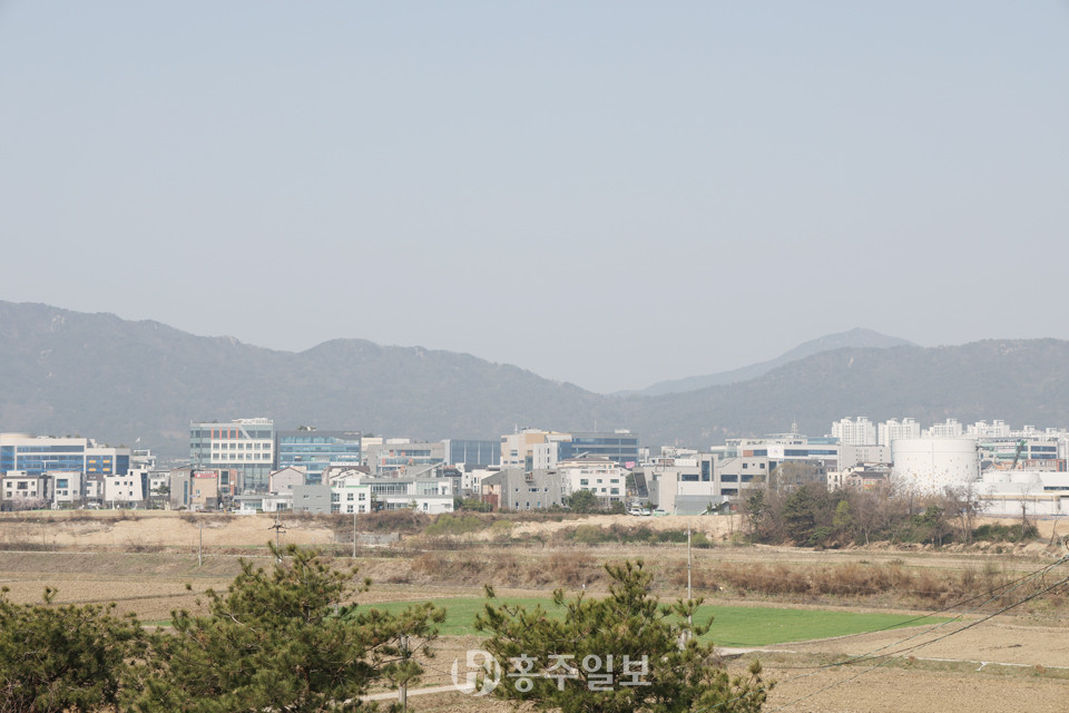 용봉산(왼쪽 산)과 뫼너미고개(중앙 낮은 곳)을 중심으로 오른쪽 수암산의 병풍에 둘러 쌓인 충남도청 내포신도시 전경.