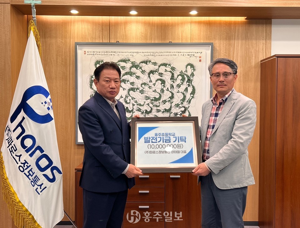 장태철 대표(왼쪽)가 모교인 홍주초등학교(교장 정관호)에 발전기금 1000만 원을 기탁했다.